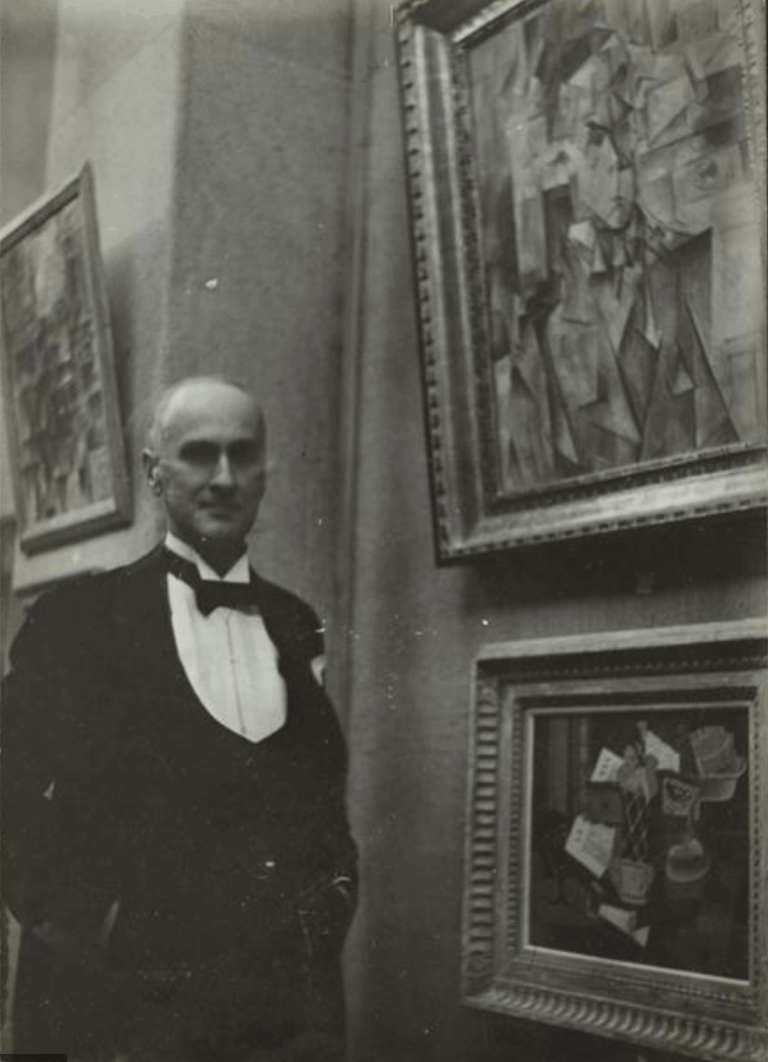 Wilhelm Uhde posant devant son portrait exécuté par Picasso en 1910